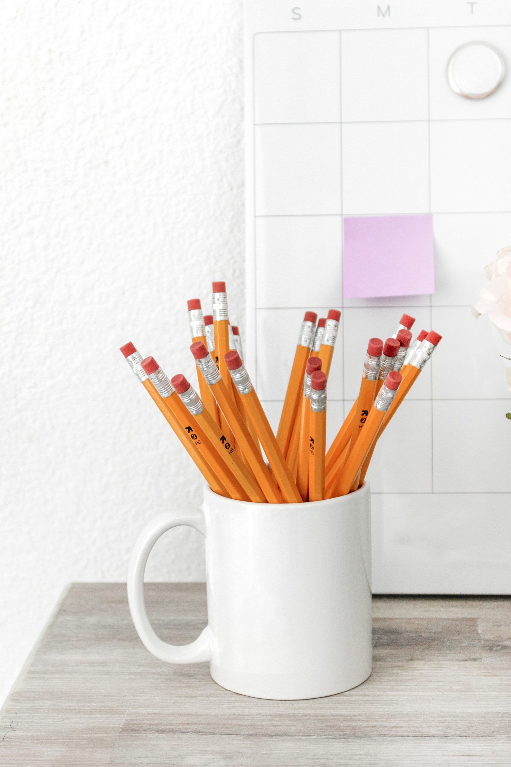 Robyn-Robyn-close-up desktop diplaying a cup of yellow pencils, and a monthly magnetic Calendar-educate-educate